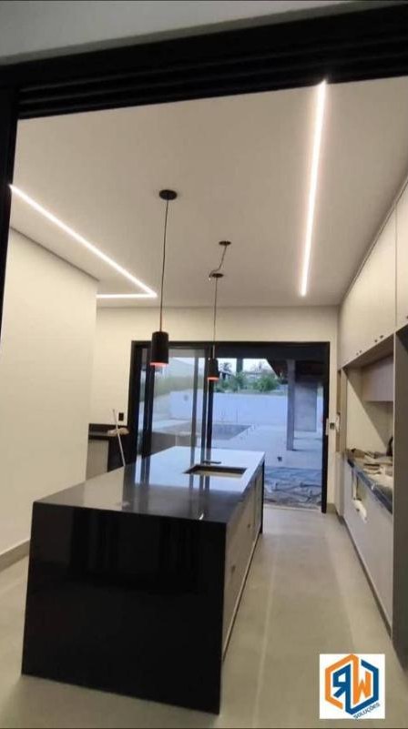 Cozinha com perfil de LED de sobrepor no teto e dois pendentes sobre a ilha